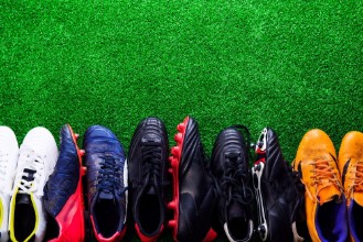 Bild på Various cleats against green artificial turf studio shot