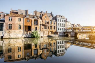 Bild på Riverside view with beautiful old buildings and water channel during the morning light in Gent city Belgium