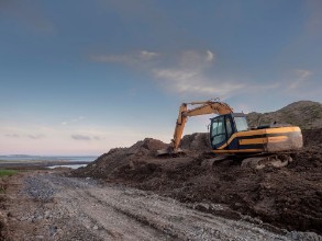 Picture of Digger working on a construction site clean blue sky Orange color of the digger