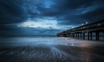 Image de Twilight dusk landscape of pier stretching out into sea with moo