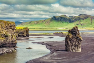 Bild på The black sand beach with typical Icelandic mountain landscapes