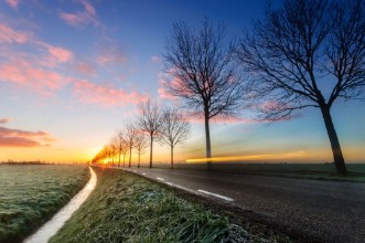 Picture of A sunrise on a rural road cars passing by