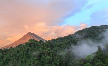 Bild på Sunset by Arenal Volcano in Costa Rica cloud forest clouds rise from the jungle floor