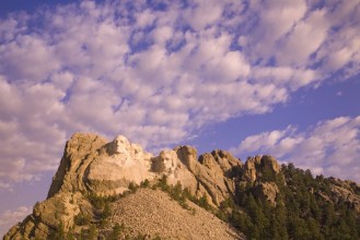 Bild på White puffy clouds behind Presidents George Washington Thomas Jefferson Teddy Roosevelt and Abraham Lincoln at Mount Rushmore National Memorial South Dakota